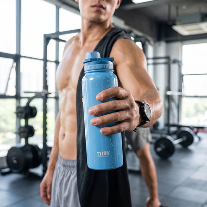 un homme dans une salle de sport avec une gourde isotherme